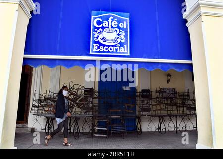 210115 -- HAVANNA, 15. Januar 2021 -- Eine Frau, die Eine Gesichtsmaske trägt, läuft an einem geschlossenen Café in Havanna, Kuba, 14. Januar 2021 vorbei. Die Kommunalregierung in Havanna kündigte als Reaktion auf die COVID-19-Pandemie neue restriktive Maßnahmen an, da am Mittwoch landesweit 550 neue Fälle gemeldet wurden, was am sechsten Tag in Folge einen neuen Tagesrekord darstellt. Foto von /Xinhua CUBA-HAVANA-COVID-19-FÄLLE JoaquinxHernandez PUBLICATIONxNOTxINxCHN Stockfoto