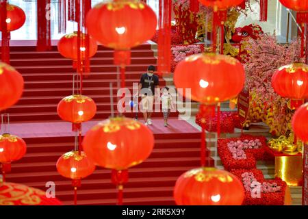 210118 -- PEKING, 18. Januar 2021 -- Menschen, die Gesichtsmasken tragen, gehen in der Nähe der chinesischen Neujahrsdekorationen in einem Einkaufszentrum mit wenigen Kunden, aufgrund einer Bewegungskontrollverordnung zur Kontrolle der Ausbreitung von COVID-19 in Kuala Lumpur, Malaysia, 17. Januar 2021. Foto von /Xinhua XINHUA FOTOS DES TAGES ChongxVoonxChung PUBLICATIONxNOTxINxCHN Stockfoto