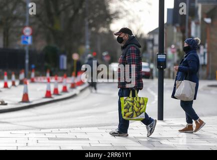 210122 -- KINGSTON UPON THAMES, 22. Januar 2021 -- Menschen mit Gesichtsmasken gehen am 21. Januar 2021 auf einer Straße in Kingston upon Thames, Großbritannien. Weitere 1.820 Menschen in Großbritannien sind innerhalb von 28 Tagen nach einem positiven Coronavirus-Test gestorben, die höchste Zahl von Todesfällen, die an einem einzigen Tag seit Beginn des Ausbruchs in Großbritannien gemeldet wurden, laut offiziellen Zahlen, die am Mittwoch veröffentlicht wurden. GROSSBRITANNIEN-KINGSTON UPON THAMES-COVID-19-TODESOPFER HANXYAN PUBLICATIONXNOTXINXCHN Stockfoto