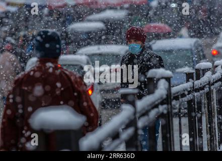 210123 -- SRINAGAR, 23. Januar 2021 -- Ein Mann mit einer Gesichtsmaske spaziert im Schnee in Srinagar City, der Sommerhauptstadt des von Indien kontrollierten Kaschmirs, 23. Januar 2021. Ein Schneefall traf am Samstag das von Indianern kontrollierte Kaschmir. KASCHMIR-SRINAGAR-SNOWFALL JavedxDar PUBLICATIONxNOTxINxCHN Stockfoto