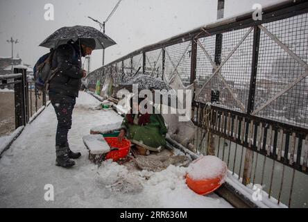 210123 -- SRINAGAR, 23. Januar 2021 -- Eine Frau verkauft Fisch bei Schneefall in Srinagar City, der Sommerhauptstadt des von Indien kontrollierten Kaschmirs, 23. Januar 2021. Ein Schneefall traf am Samstag das von Indianern kontrollierte Kaschmir. KASCHMIR-SRINAGAR-SNOWFALL JavedxDar PUBLICATIONxNOTxINxCHN Stockfoto