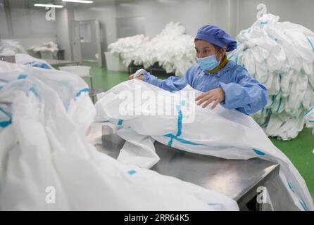 210126 -- CHONGQING, 26. Januar 2021 -- Ein Arbeiter überprüft die Qualität von Schutzanzügen in einer Werkstatt im Fengdu County von Chongqing, Südwestchina, 25. Januar 2021. Die Fabrik stellt rund um die Uhr Schutzanzüge her, um die Inlandsnachfrage zu decken, während das Land gegen den jüngsten Ausbruch der COVID-19-Fälle kämpft. CHINA-CHONGQING-FENGDU-PROTECTIVE SUITS-PRODUCTION CN LIUXCHAN PUBLICATIONXNOTXINXCHN Stockfoto