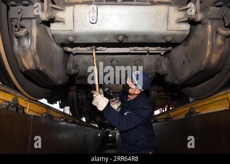 210126 -- CHONGQING, 26. Januar 2021 -- Ein Techniker unterhält einen Zug in der Werkstatt in Chongqing Passenger Section der China Railway Chengdu Group Co., Ltd. In Chongqing, Südwestchina, 26. Januar 2021. Chongqing Passenger Section der China Railway Chengdu Group Co., Ltd. Führt Instandhaltungsarbeiten für die wichtigsten Teile der Züge durch, um sich auf den jährlichen Reiserouten des Landes auf dem Frühlingsfest vorzubereiten. CHINA-CHONGQING-RAILWAY-MAINTENANCE CN TangxYi PUBLICATIONxNOTxINxCHN Stockfoto