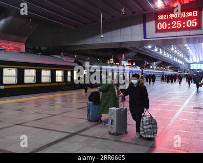 210128 -- PEKING, 28. Januar 2021 -- Passagiere gehen am Pekinger Bahnhof, in Peking, Hauptstadt von China, am 28. Januar 2021 zu Fuß an Bord ihres Zuges. Das Spring Festival Travel Rush, bekannt als die weltweit größte jährliche Migration von Menschen, dauert 40 Tage vom 28. Januar bis zum 8. März dieses Jahres. CHINA-SPRING FESTIVAL-TRAVEL RUSH CN ZHANGXCHENLIN PUBLICATIONXNOTXINXCHN Stockfoto