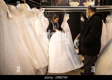 210128 -- TEHERAN, 28. Januar 2021 -- am 28. Januar 2021 kauft man in einem Hochzeitskleiderladen in Teheran, Iran. Für viele Iraner, die den Knoten binden wollen, waren sie gezwungen, ihre Hochzeitspläne zu ändern und anzupassen, da sie mit Hindernissen konfrontiert waren, die durch die COVID-19-Pandemie verursacht wurden. Foto von /Xinhua IRAN-TEHRAN-COVID-19-WEDDING PLAN-CHANGE AhmadxHalabisaz PUBLICATIONxNOTxINxCHN Stockfoto