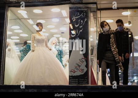 210128 -- TEHERAN, 28. Januar 2021 -- Menschen gehen am 28. Januar 2021 aus einem Hochzeitskleiderladen in Teheran, Iran. Für viele Iraner, die den Knoten binden wollen, waren sie gezwungen, ihre Hochzeitspläne zu ändern und anzupassen, da sie mit Hindernissen konfrontiert waren, die durch die COVID-19-Pandemie verursacht wurden. Foto von /Xinhua IRAN-TEHRAN-COVID-19-WEDDING PLAN-CHANGE AhmadxHalabisaz PUBLICATIONxNOTxINxCHN Stockfoto