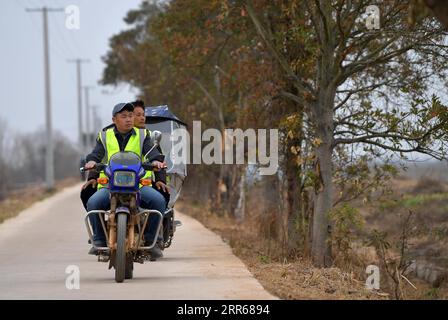 210131 -- NANCHANG, 31. Januar 2021 -- Lei Xiaoyong Front und sein Kollege fahren mit einem Motorrad auf der Kangshan Farm im Yugan County, ostchinesische Provinz Jiangxi, 30. Januar 2021. LEI Xiaoyong ist Leiter der Wildtier- und Pflanzenschutzstation der Forstverwaltung des Yugan County. Eine der Aufgaben von Lei und seinen Kollegen ist es, Zugvögel am Poyang-See zu schützen, dem größten Süßwassersee Chinas und einem wichtigen Überwinterungsort für Wasservögel in Asien. In diesem Winter flog eine große Anzahl von weißen Kranichen zur Kangshan Farm in Yugan, wo sie überwinterten, mit fast 3.000 Stockfoto