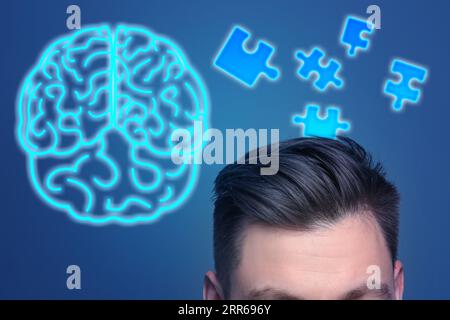 Speicher. Mann, Puzzleteile und Neongehirn auf blauem Hintergrund Stockfoto