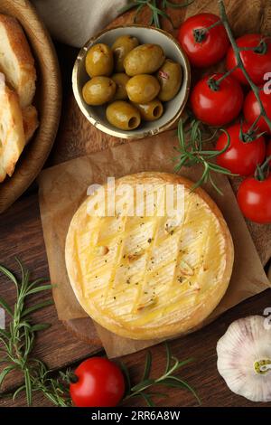 Leckerer gebackener Brie-Käse, serviert auf Holztisch, flach gelegt Stockfoto