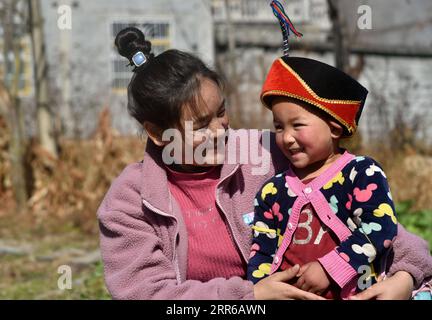 210203 -- LIANGSHAN, 3. Februar 2021 -- Bamu Yubumu L sitzt zusammen mit Wang Xueqi, ihrer jüngsten Tochter, im Dorf Taoyuan, Kreis Yuexi, Autonome Präfektur Liangshan Yi, Provinz Sichuan im Südwesten Chinas, 22. Januar 2021. Eine junge Mutter beugte sich mühsam nach vorne, um das Gewicht eines übergroßen Gepäcks auf ihrem Rücken und ein winziges Baby in ihrem Arm auszugleichen, während sie ihre Schritte vorwärts kämpfte. Dies war das Bild, das der Xinhua-Reporter in der Nähe des Nanchang-Bahnhofs in Nanchang, der ostchinesischen Provinz Jiangxi, am 30. Januar 2010 aufgenommen hat. Das Foto mit dem Titel Baby, Mom nimmt dich nach Hause berührte die Herzen von Millionen Stockfoto