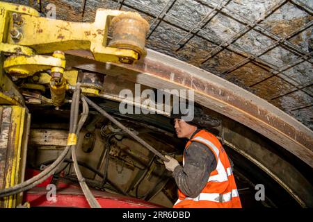 210207 -- ÜRÜMQI, 7. Februar 2021 -- Ein Arbeiter beschäftigt sich auf der Baustelle des Tianshan-Shdeparture-Tunnels in der nordwestchinesischen Autonomen Region Xinjiang Uygur, 5. Februar 2021. Der Tianshan-Shdak-Tunnel ist mit einer Gesamtlänge von etwa 22 Kilometern der derzeit längste im Bau befindliche Autobahntunnel in China. Der 2020 begonnene Tunnel, ein sechsjähriges Projekt auf der Urumqi-Yuli-Autobahn, durchquert eine kalte und hochgelegene Zone mit rauem Klima und geologischen Bedingungen. Nach der Fertigstellung und der Öffnung für den Verkehr wird es den Passagieren eine sicherere und komfortablere Reise ermöglichen und die Lage fördern Stockfoto