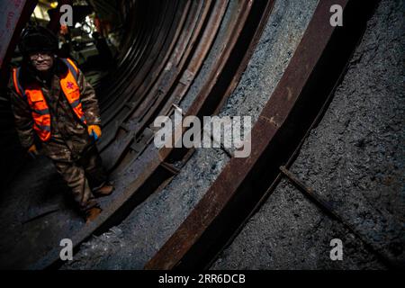 210207 -- ÜRÜMQI, 7. Februar 2021 -- Ein Arbeiter spaziert auf der Baustelle des Tianshan-Shdeparture-Tunnels in der nordwestchinesischen Autonomen Region Xinjiang Uygur, 4. Februar 2021. Der Tianshan-Shdak-Tunnel ist mit einer Gesamtlänge von etwa 22 Kilometern der derzeit längste im Bau befindliche Autobahntunnel in China. Der 2020 begonnene Tunnel, ein sechsjähriges Projekt auf der Urumqi-Yuli-Autobahn, durchquert eine kalte und hochgelegene Zone mit rauem Klima und geologischen Bedingungen. Nach der Fertigstellung und der Öffnung für den Verkehr wird es den Passagieren eine sicherere und bequemere Reise ermöglichen und die lokale Bevölkerung fördern Stockfoto