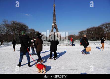 210211 -- PARIS, 11. Februar 2021 -- die Leute machen einen Spaziergang nach dem Schneefall auf dem Champ de Mars in Paris, Frankreich, 10. Februar 2021. Zwölf Regionen Frankreichs wurden aufgrund von Schneefällen und Eis in orange gemeldet, nachdem eine bemerkenswerte Schneesituation die nordöstlichen Departements des Landes getroffen hatte, teilte die Wetteragentur Meteo France am Mittwoch mit. FRANCE-PARIS-COLD-WEATHER GaoxJing PUBLICATIONxNOTxINxCHN Stockfoto