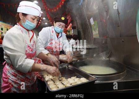 210212 -- JINCHANG, 12. Februar 2021 -- Logistikmitarbeiter kochen Abendessen für Bergleute in der dritten Bergbauzone der Jinchuan-Gruppe in Jinchang, nordwestchinesische Provinz Gansu, 11. Februar 2021. Im dunklen Bergwerk in einer Tiefe von mehr als 600 Metern brüllen die Bergbaumaschinen und das Erz auf dem Förderband glänzt mit metallischem Glanz. Es ist die dritte Bergbauzone der Jinchuan-Gruppe in Jinchang, einer der wichtigsten Produktionsstätten des Landes für Nickel, Kobalt und Kupfer. Arbeiter, die während des Frühlingsfestes nicht nach Hause zurückkehrten, hielten an ihren Posten fest, um den Bergbaubetrieb auf geordnete Weise sicherzustellen. Stockfoto