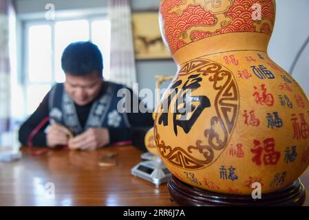 210218 -- HORGOS, 18. Februar 2021 -- Cao Guangyao arbeitet in seinem Atelier in Horgos, Nordwestchinas autonomer Region Xinjiang Uygur, am 6. Februar 2021 an pyrographischen Kalabasarbeiten. Cao Guangyao ist ein 45-jähriger Bauer in Horgos. Er ist auch bei den Einheimischen als Künstler für seine pyrographische Kalabaskunst bekannt. Cao interessierte sich vor 8 Jahren für pyrografische Kreationen aus Fernsehsendungen und begann seitdem mit seiner eigenen Schöpfung. Trotz fehlender Berufsausbildung unternahm Cao immer wieder Kunstversuche mit Liebe und Leidenschaft in der Slacksaison der landwirtschaftlichen Produktion. N Stockfoto