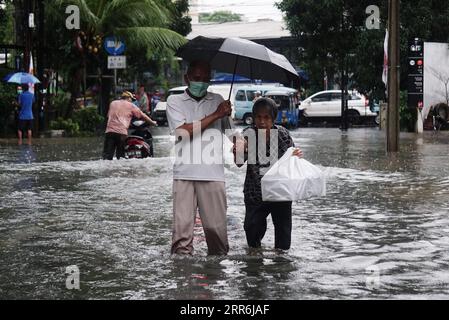 210218 -- JAKARTA, 18. Februar 2021 -- Menschen gehen durch Hochwasser nach starkem Regen in Jakarta, Indonesien, 18. Februar 2021. Foto von INDONESIA-JAKARTA-FLOODE AryaxManggala PUBLICATIONxNOTxINxCHN Stockfoto