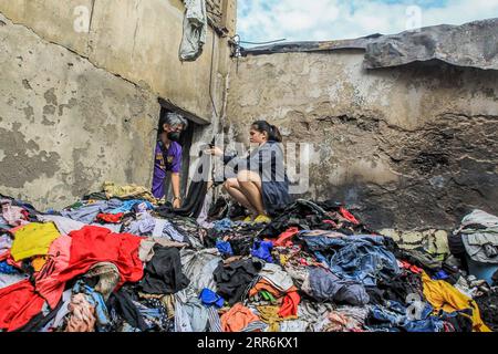 210221 -- MANILA, 21. Februar 2021 -- Bewohner suchen nach intakter Kleidung aus ihrem verkohlten Laden nach einem Brand in einem Slum-Gebiet in Manila, Philippinen, am 21. Februar 2021. Fünf Menschen starben, als ein sechsstündiger Brand rund 300 Häuser im Tondo-Viertel von Manila auf den Philippinen zerstörte, sagte ein Feuerwehrmann am Sonntag. PHILIPPINEN-MANILA-FIRE RouellexUmali PUBLICATIONxNOTxINxCHN Stockfoto