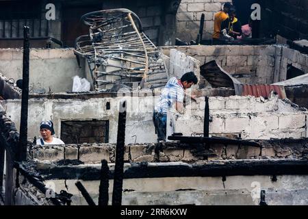 210221 -- MANILA, 21. Februar 2021 -- Bewohner suchen nach ihrem Eigentum in ihren verbrannten Häusern nach einem Brand in einem Slum-Gebiet in Manila, Philippinen am 21. Februar 2021. Fünf Menschen starben, als ein sechsstündiger Brand rund 300 Häuser im Tondo-Viertel von Manila auf den Philippinen zerstörte, sagte ein Feuerwehrmann am Sonntag. PHILIPPINEN-MANILA-FIRE RouellexUmali PUBLICATIONxNOTxINxCHN Stockfoto