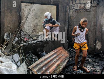 210221 -- MANILA, 21. Februar 2021 -- die Bewohner werden nach einem Brand in einem Slum-Gebiet in Manila, Philippinen, am 21. Februar 2021 vor ihrem verbrannten Haus gesehen. Fünf Menschen starben, als ein sechsstündiger Brand rund 300 Häuser im Tondo-Viertel von Manila auf den Philippinen zerstörte, sagte ein Feuerwehrmann am Sonntag. PHILIPPINEN-MANILA-FIRE RouellexUmali PUBLICATIONxNOTxINxCHN Stockfoto