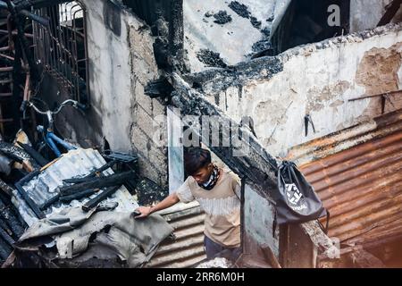 210221 -- MANILA, 21. Februar 2021 -- Ein Bewohner sucht nach seinem Eigentum in seinem verkohlten Haus nach einem Brand in einem Slum-Gebiet in Manila, Philippinen, am 21. Februar 2021. Fünf Menschen starben, als ein sechsstündiger Brand rund 300 Häuser im Tondo-Viertel von Manila auf den Philippinen zerstörte, sagte ein Feuerwehrmann am Sonntag. PHILIPPINEN-MANILA-FIRE RouellexUmali PUBLICATIONxNOTxINxCHN Stockfoto