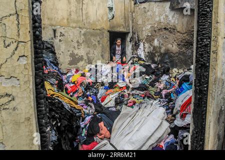 210221 -- MANILA, 21. Februar 2021 -- Eine Bewohnerin sucht nach intakten Kleidungsstücken aus ihrem verkohlten Laden nach einem Brand in einem Slum-Gebiet in Manila, Philippinen, am 21. Februar 2021. Fünf Menschen starben, als ein sechsstündiger Brand rund 300 Häuser im Tondo-Viertel von Manila auf den Philippinen zerstörte, sagte ein Feuerwehrmann am Sonntag. PHILIPPINEN-MANILA-FIRE RouellexUmali PUBLICATIONxNOTxINxCHN Stockfoto