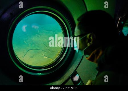 210221 -- CHONGQING, 21. Februar 2021 -- Ein Besucher schaut aus einem Fenster im Baiheliang Museum, Chinas erstes Unterwassermuseum, das etwa 40 Meter unter der Oberfläche in den Oberläufen des Yangtze vor der Küste von Fuling City, südwestchinesische Gemeinde Chongqing, am 21. Februar 2021 errichtet wurde. Das Baiheliang Museum wurde kürzlich nach einer viermonatigen Renovierung wieder eröffnet. Baiheliang, wörtlich White Crane Ridge, ist ein 1.600 Meter langer und 25 Meter breiter, glatter Steinrücken mit Inschriften über Chinas längsten Fluss, der von 763 in der Tang-Dynastie bis zum frühen 20. Jahrhundert datiert wurde. Auf dem Riesen Stockfoto