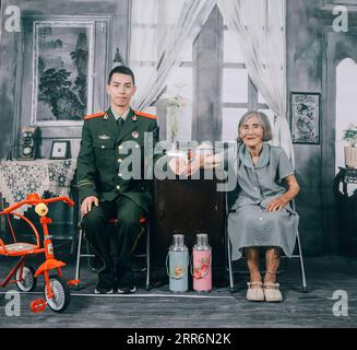 210223 -- NANCHANG, 23. Februar 2021 -- ein Foto zeigt Zhang Jiagang, wie er 2020 ein Hochzeitsfoto mit Oma Tang Caiying macht. Zhang Jiagang, 24 Jahre alt, heute Feuerwehrmann im Fenyi County der Stadt Xinyu, wurde vor 24 Jahren von Tang Caiying, der jetzt 85 Jahre alt ist, als verlassen und adoptiert aufgefunden. Tang Caiying und sein Mann zogen ihre eigene Tochter und sechs Findlinge auf eigene Faust auf Gehältern auf, verkauften Gemüse und Abfall. 2001 begannen Feuerwehrleute im Fenyi County, Tang Caiying und ihrer Familie zu helfen, nachdem sie ihre Erfahrung kennengelernt hatten, und die Hilfe dauerte 20 Jahre. Im Jahr 2016 Wurde Zhang Jiagang Geboren Stockfoto