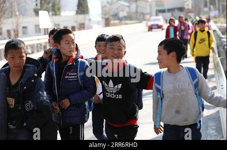 210226 -- LIANGSHAN, 26. Februar 2021 -- Jijue Jizhu 2nd R und seine Freunde gehen nach der Schule in der südwestchinesischen Provinz Sichuan am 24. Februar 2021 nach Hause. An einem verschneiten Tag im Februar 2018 ging ein neunjähriger Junge mit seinem jüngeren Bruder auf dem Rücken in der Autonomen Präfektur Liangshan Yi in der Provinz Sichuan bergab, auf dem Weg zum Haus seines Großvaters mütterlicherseits an einem Umzugsort. Xinhua-Korrespondent hat den Moment festgehalten. Das Foto bewegte viele Chinesen. Mit Hilfe gezielter Armutsbekämpfung verabschiedete sich Jijue Jizhus Familie von dem lehmhaus in einer bergregion und Stockfoto