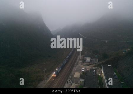 210228 -- BAISE, 28. Februar 2021 -- Luftbild zeigt einen Zug, der am Bahnhof Rongbai entlang der Nanning-Kunming-Bahn vorbeifährt, 25. Februar 2021. CHINA-NANNING-KUNMING EISENBAHNLANDSCHAFT CN ZHANGXAILIN PUBLICATIONXNOTXINXCHN Stockfoto