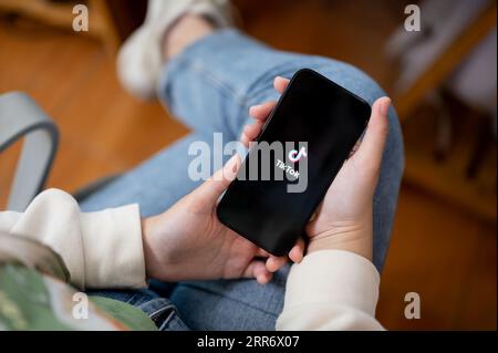 Chiang mai, Thailand - 6. September 2023: Nahaufnahme einer Frau, die ein iPhone14 mit einem TikTok-Logo auf dem Bildschirm hält. TikTok-Logo. Eine Frau, die die TikTok-App verwendet Stockfoto