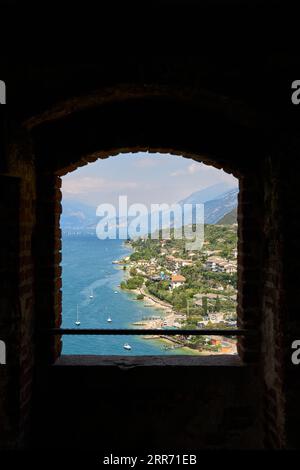 Blick durch ein Fenster auf die Scaliger Burg, Castello Scaligero an der Küste des Gardasees bei Malcesine in Italien Stockfoto