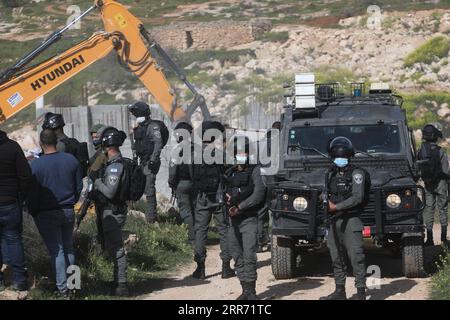210308 -- HEBRON, 8. März 2021 -- israelische Soldaten und Mitglieder der israelischen Grenzpolizei stehen als Bagger auf und zerstören ein palästinensisches Haus, das sich im Bau befindet, und behaupten, es sei ohne Erlaubnis gebaut worden, in der Stadt Bani Naim in der Nähe der Westbank-Stadt Hebron, 8. März 2021. Foto von /Xinhua MIDEAST-HEBRON-HAUS-ABRISS MamounxWazwaz PUBLICATIONxNOTxINxCHN Stockfoto