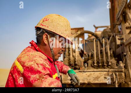 210310 --ÜRÜMQI, 10. März 2021 -- Ein Mitarbeiter des geophysikalischen Vermessungsteams arbeitet in der Taklimakan-Wüste, Nordwestchinas Autonome Region Xinjiang Uygur, 24. Februar 2021. Die Taklimakan-Wüste im Tarimbecken der Autonomen Region Xinjiang Uygur im Nordwesten Chinas ist eine große petroreiche Region in China und eine der am schwierigsten zu erkundenden Regionen aufgrund ihrer rauen Bodenumgebung und komplizierten Untergrundbedingungen. Um die Öl- und Gasressourcen zu erforschen, sind mehrere Prozesse erforderlich, einschließlich der Durchführung geophysikalischer Vermessungen, um seismische Daten zu sammeln, um eine solide Grundlage für f zu schaffen Stockfoto