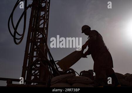 210310 --ÜRÜMQI, 10. März 2021 -- Ein Mitarbeiter des geophysikalischen Vermessungsteams arbeitet in der Taklimakan-Wüste, Nordwestchinas Autonome Region Xinjiang Uygur, 24. Februar 2021. Die Taklimakan-Wüste im Tarimbecken der Autonomen Region Xinjiang Uygur im Nordwesten Chinas ist eine große petroreiche Region in China und eine der am schwierigsten zu erkundenden Regionen aufgrund ihrer rauen Bodenumgebung und komplizierten Untergrundbedingungen. Um die Öl- und Gasressourcen zu erforschen, sind mehrere Prozesse erforderlich, einschließlich der Durchführung geophysikalischer Vermessungen, um seismische Daten zu sammeln, um eine solide Grundlage für f zu schaffen Stockfoto