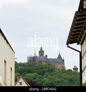 Blick durch eine Lücke zwischen den Häusern zum Schloss in Wernigerode in Deutschland auf einem Berg Stockfoto