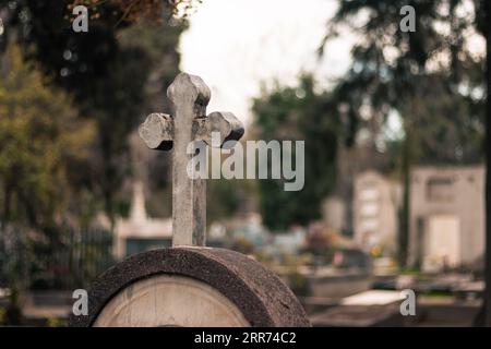 Blick auf das Kreuz auf einem Grabstein auf einem Friedhof in der Natur im Freien. Stockfoto