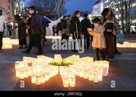 210311 -- TOKIO, 11. März 2021 -- Ein Mädchen macht Fotos von Papierlaternen mit Eulogen, um der Opfer des großen Erdbeben- und Tsunamis in Tokio, Japan am 11. März 2021 zu gedenken. JAPAN-BEBEN-TSUNAMI-JUBILÄUM DuxXiaoyi PUBLICATIONxNOTxINxCHN Stockfoto