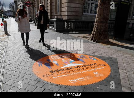 210312 -- LONDON, 12. März 2021 -- Foto vom 11. März 2021 zeigt Menschen, die an einem Schild auf der Straße vor dem NHS COVID-19 Impf Centre im Science Museum in London, Großbritannien, vorbeigehen. Laut NHS National Health Service haben Impfzentren im Westminster Abbey and Science Museum eröffnet. GROSSBRITANNIEN-LONDON-COVID-19-IMPFZENTREN HanxYan PUBLICATIONxNOTxINxCHN Stockfoto