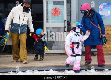 210312 -- ÜRÜMQI, 12. März 2021 -- das Foto vom 4. März 2021 zeigt den Snowboardtrainer Xu Xiujuan 1st R, der die Hand eines Lerners hält, während ihr Mann Wang Wen 1st L die Hand ihres Sohnes hält, bevor er im Baiyun Ski Resort in Ürümqi, der nordwestchinesischen Autonomen Region Xinjiang Uygur, eine Trainingsstunde absolviert. Der 31-jährige Xu Xiujuan ist heute technischer Direktor und Mitglied des rates der Xinjiang Skiverband. Im Alter von 9 Jahren begann sie in ihrer Heimatstadt Harbin, der Hauptstadt der nordöstlichen chinesischen Provinz Heilongjiang, Skifahren zu lernen. Während ihrer Karriere als Athletin gewann Xu je ein großes ach Stockfoto