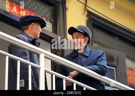 210316 -- TAIYUAN, 16. März 2021 -- Liu Qingji R plaudert mit einem anderen Dorfbewohner in einer Wohnanlage für umgesiedelte Dorfbewohner in Yukou Stadt im Fangshan County, nordchinesische Provinz Shanxi, 9. März 2021. Shijiamao ist ein kleines Dorf in zerklüfteten Bergregionen mit wenig Niederschlag. Wie andere Dorfbewohner hier, hat Liu Qingji, ein 85-jähriger Bauer, früher Landwirtschaft betrieben, die den Elementen ausgeliefert war. Nachdem Liu viele Jahre in einem düsteren Yaodong gewohnt hatte, einem Haus, das in die harte Erde gebaut wurde, die auf dem Loess Plateau in Nordchina verbreitet ist, hoffte er, die Lebensbedingungen zu verbessern und Zugang zu haben Stockfoto