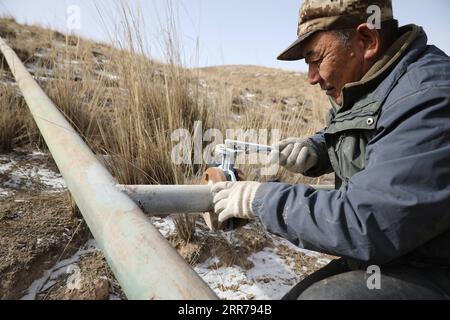 210321 -- SUNAN, 21. März 2021 -- Gu Zhengli inspiziert die Pipeline in der Dahe Township, Yugu Autonomous County of Sunan, nordwestchinesische Provinz Gansu, 20. März 2021. Gu Zhengli, 59, arbeitet seit 42 Jahren an der Front des Tanggaer Water Conservancy Project in der Gemeinde Dahe, um die Sicherheit des Trinkwassers für die Menschen und die Tiere vor Ort zu gewährleisten. Da die jährlichen Niederschläge in der Stadt nur 150 bis 300 Millimeter betragen, ist das Tanggaer Water Conservancy Project buchstäblich die Lebensader der örtlichen Hirten. Jeden Morgen steht Gu früh auf und betreibt eine Pumpe, um Wasser aus der Pumpstation zu fördern Stockfoto