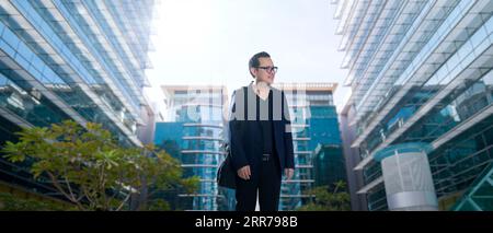 Junger Geschäftsmann, der gerne im Business Center spazieren geht Stockfoto