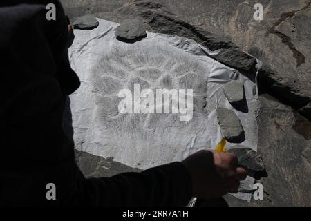 210323 -- SUNAN, 23. März 2021 -- du Chengfeng reibt für ein Felsmalerei auf dem Leishan-Berg im Yugu Autonomous County of Sunan, nordwestchinesische Provinz Gansu, 22. März 2021. Du Chengfeng, 45, wurde aus einer Hirtenfamilie geboren. Aus Interesse und Leidenschaft hat er in den letzten 20 Jahren über 12.000 Felsmalereien auf den Qilian Mountains gesammelt. Er verbringt oft über 100 Tage im Jahr auf der Suche nach verschiedenen Felsmalereien im tiefen Berg. Du begann 2012 im Kultursektor zu arbeiten. Auf Vorschlag der lokalen Behörden zur Verwaltung der kulturellen Herita Stockfoto