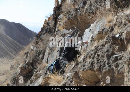 210323 -- SUNAN, 23. März 2021 -- du Chengfeng misst die Größe eines Felsengemäldes auf dem Yumu-Berg im Yugu Autonomous County of Sunan, nordwestchinesische Provinz Gansu, 22. März 2021. Du Chengfeng, 45, wurde aus einer Hirtenfamilie geboren. Aus Interesse und Leidenschaft hat er in den letzten 20 Jahren über 12.000 Felsmalereien auf den Qilian Mountains gesammelt. Er verbringt oft über 100 Tage im Jahr auf der Suche nach verschiedenen Felsmalereien im tiefen Berg. Du begann 2012 im Kultursektor zu arbeiten. Auf Vorschlag der lokalen Behörden zur Verwaltung der kulturellen Herita Stockfoto