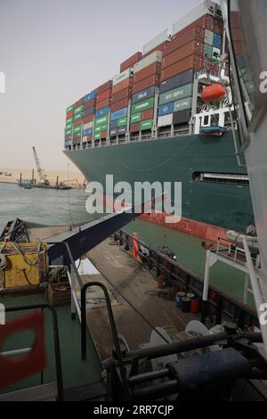 210325 -- KAIRO, 25. März 2021 -- Ein Rettungsschiff arbeitet an der Stelle eines Containerschiffs, das am 25. März 2021 auf dem Suez-Kanal von Ägypten eingeschlossen wurde. Die Seefahrt im Suez-Kanal wurde vorübergehend ausgesetzt, bis die Wiederauftriebsarbeiten auf einem Schiff, das in einem neuen Kurs gelandet ist, abgeschlossen sind, sagte Osama Rabie, Vorsitzende des SCA, am Donnerstag. Das jemals gegebene 224.000-Tonnen-Containerschiff, ein unter Panama fahrendes Containerschiff, wurde am frühen Dienstag in der neuen Passage geerdet, nachdem es die Fähigkeit verloren hatte, bei starkem Wind und einem Staubsturm zu steuern, sagte der SCA in einer Erklärung am Mittwoch. /Handout über Xinhua EGYPT-SUEZ CANAL-CARGO CONTAINER Stockfoto