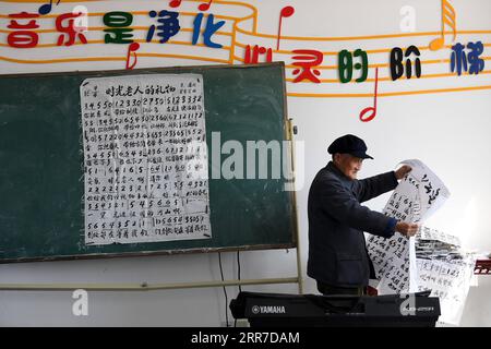 210326 -- HEFEI, 26. März 2021 -- Yan Mingyou arrangiert das Notenblatt eines Liedes an der Zhuwan Primary School in der Zhuwan Township im Dingyuan County, Chuzhou City, ostchinesische Provinz Anhui, 23. März 2021. Yan Mingyou, 92, ist immer noch als Lehrer für Musik an ländlichen Grundschulen tätig. Als Yan 1990 als Landlehrer in den Ruhestand ging, hat er sich freiwillig engagiert, um Schülern in ländlichen Schulen Musik zu vermitteln. Im Jahr 1953 verließ Yan die Armee und kehrte in seine Heimatstadt Zhuwan Township im Dingyuan County zurück. Er gab eine bessere Stelle in der lokalen Verwaltung auf und entschied sich, in ländlichen Schulen zu arbeiten, wo er verschiedene Fächer unterrichtete Stockfoto