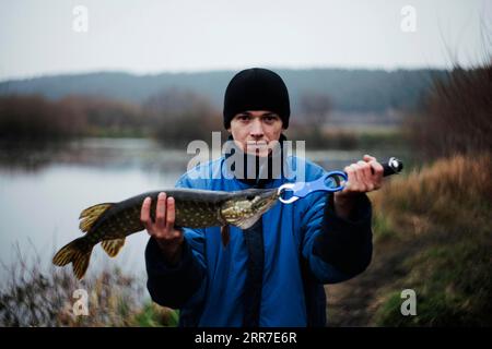 Porträtmann, der Hechte hält Stockfoto