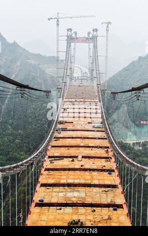 210327 -- GUIDING, 27. März 2021 -- Foto aufgenommen am 27. März 2021 zeigt die Baustelle der Yangbaoshan Grand Bridge im Guiding County in der südwestlichen chinesischen Provinz Guizhou. Mit einer Hauptspannweite von 650 Metern erstreckt sich die große Brücke, die Teil des Guiyang-Huangping Highway ist, über 1.112 Meter. CHINA-GUIZHOU-YANGBAOSHAN BRÜCKENBAU CN YANGXWENBIN PUBLICATIONXNOTXINXCHN Stockfoto