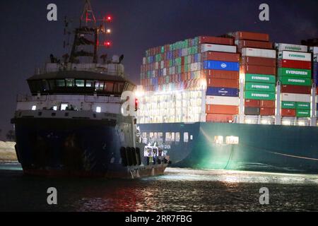 210327 -- SUEZ CANAL EGYPT, 27. März 2021 -- Ein Rettungsschiff arbeitet am Standort des festgefahrenen Containerschiffes, das jemals am 27. März 2021 auf dem Suez-Kanal in Ägypten eingesetzt wurde. Mindestens 321 Schiffe sind derzeit um den Suez-Kanal gestaut und warten auf die Rettung des riesigen Containerschiffs, das seit Dienstag feststeckt und die lebenswichtige Wasserstraße blockiert, sagte Osama Rabie, Vorsitzende der Suez Canal Authority SCA, am Samstag. Er wies darauf hin, dass 14 Schleppboote arbeiten, um jemals aus allen Richtungen gegeben zu retten. EGYPT-SUEZ CANAL-STUCK CONTAINER SHIP-SALVAGE AHMEDXGOMAA PUBLICATIONXNOTXINXCHN Stockfoto