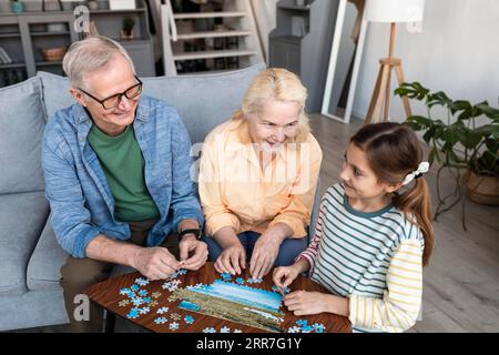 Großelternmädchen macht Puzzle mit mittlerer Schussweite Stockfoto